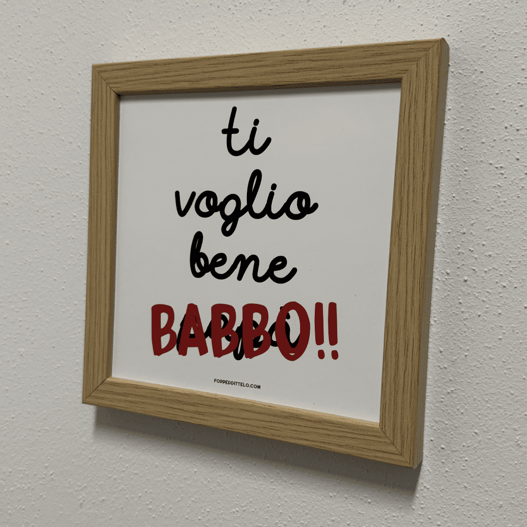 Stampa «Ti voglio bene babbo» in cornice di legno appesa a una parete chiara