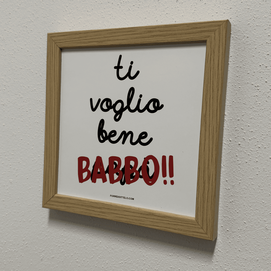 Stampa «Ti voglio bene babbo» in cornice di legno appesa a una parete chiara
