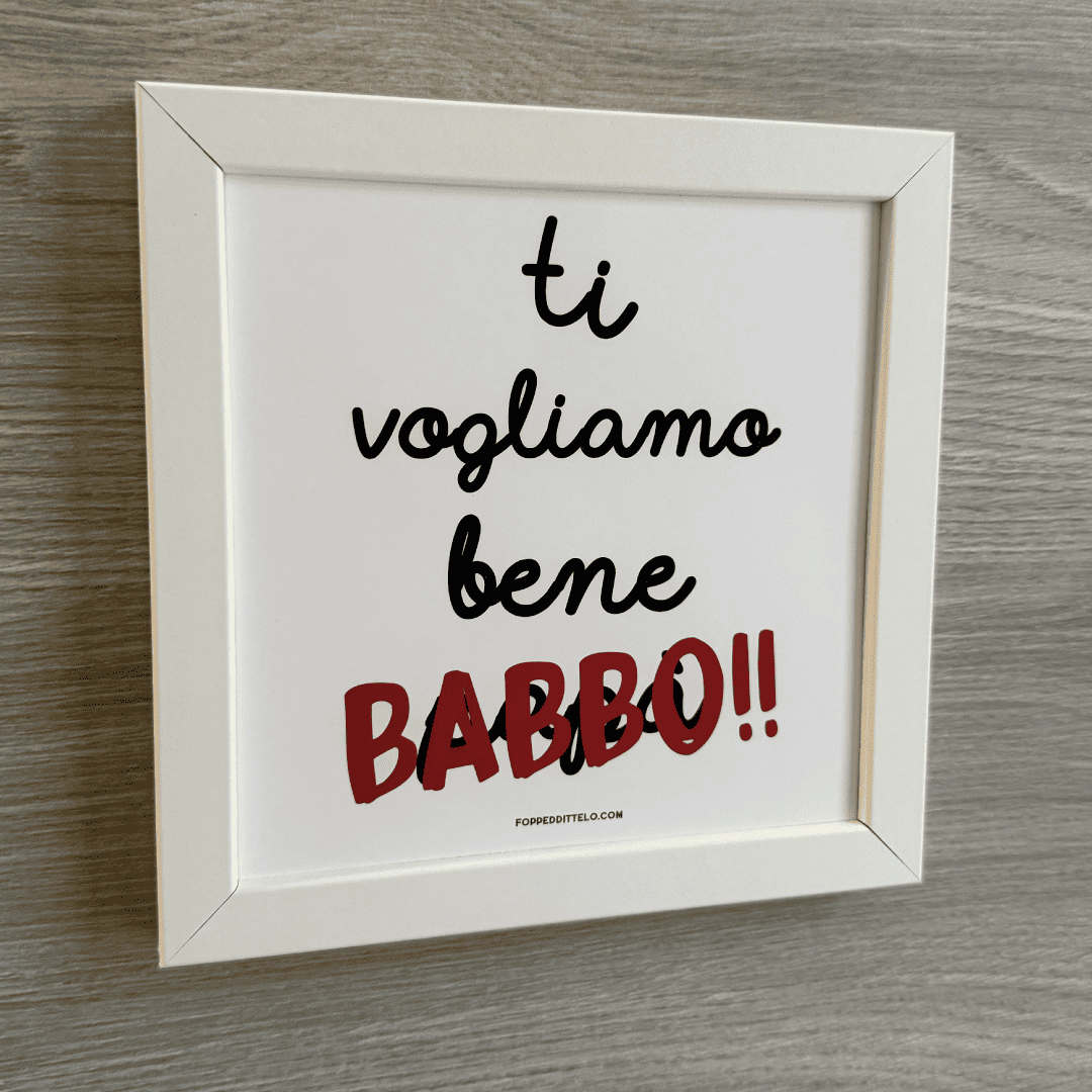 Stampa «Ti vogliamo bene babbo» in cornice bianca su una parete di legno