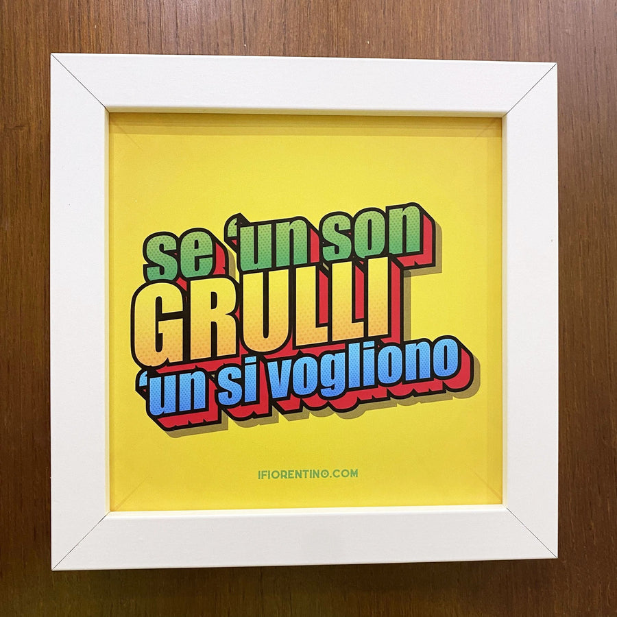 Stampa gialla «Se 'un son grulli 'un si vogliono» in cornice bianca su parete di legno